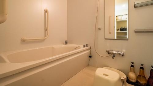 a bathroom with a tub and a toilet and a sink at LiVEMAX Resort Izu Kogen Terrace & Spa in Ito