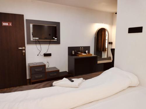 a bedroom with a bed and a tv on the wall at RKs HOME STAY in Shillong