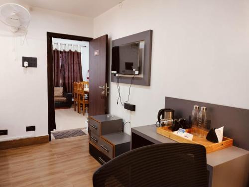 a living room with a desk and a television at RKs HOME STAY in Shillong