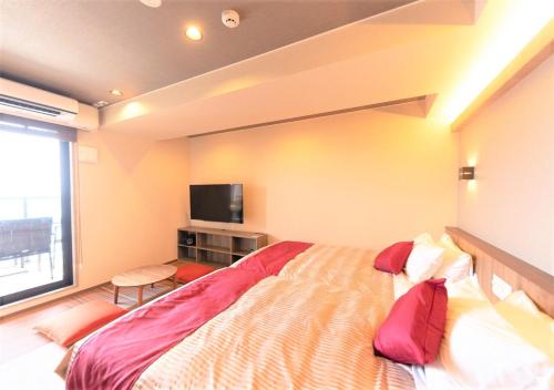 a bedroom with a large bed and a flat screen tv at LiVEMAX RESORT Atami Sea Front in Atami