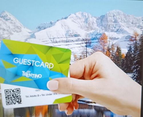 a hand holding a credit card with mountains in the background at Dom City Apartments in Trento