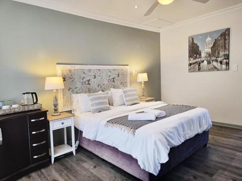 a bedroom with a large white bed with two lamps at Breathe Inn in George