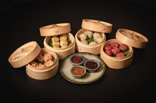 four wooden containers filled with different types of food at Grand Mirage Dhanbad, a member of Radisson Individuals in Dhanbād