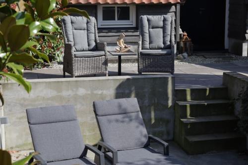 two chairs and a table on a porch with stairs at Dreams and Wellness in Vorstenbosch