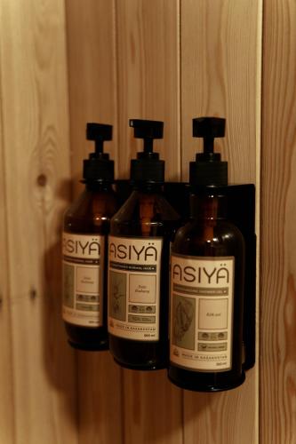 a group of four bottles of soap on a wall at Pana Ayusai in Almaty
