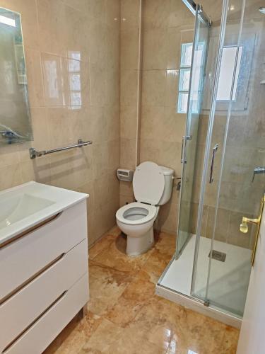 a bathroom with a toilet and a glass shower at Sunny Balcony in Oliva