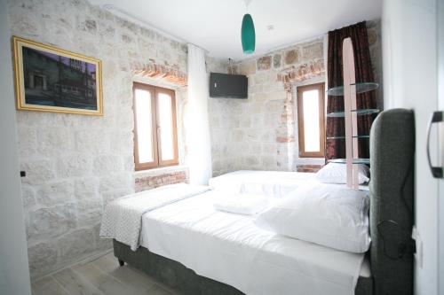 a bedroom with a large bed with white sheets at Rooms Malo more Trogir in Trogir