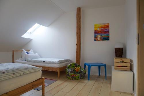a bedroom with two beds and a blue stool at Ferienwohnung-Milena in Gundelfingen an der Donau