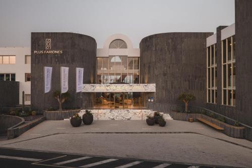 a building with a courtyard in front of it at Plus Fariones Suite Hotel in Puerto del Carmen