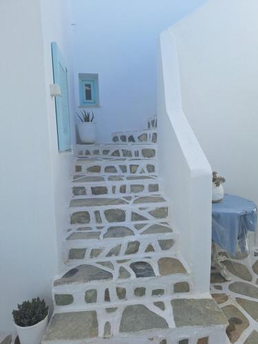 a staircase in a white room with a blue light at Paros Carmel studio-apartment in Logaras