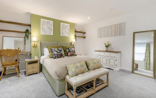 ein Schlafzimmer mit einem Bett, einem Spiegel und einem Stuhl in der Unterkunft 2 Bedroom Family Apartment in Bridlington