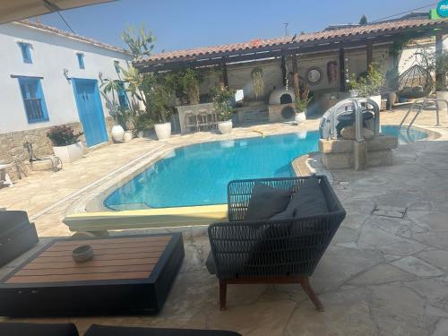 a large swimming pool with a chair and a table at Little Stone House in Lymbia