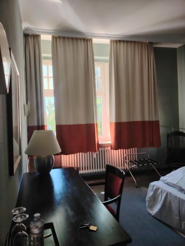 a hotel room with a table and a bed at Hotel Drei Kronen in Lippstadt