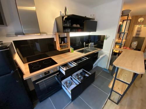 une petite cuisine avec un évier et une cuisinière dans l'établissement appartement de village avec terrasse, à Plaissan