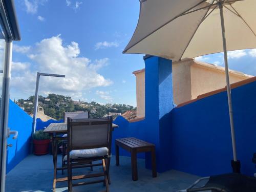 a chair and a table and an umbrella on a balcony at Village house for 4 people with terrace in Pierrefeu-du-Var
