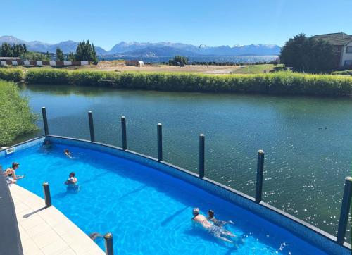 a group of people swimming in a pool in a river at Blue Aparts Dina Huapi Bariloche in Dina Huapi