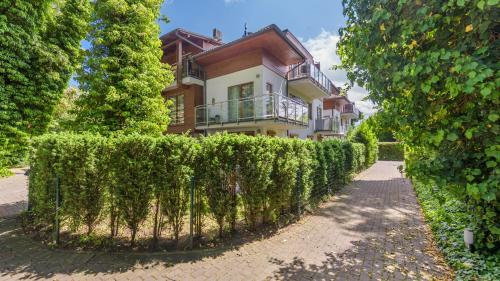 a house with a hedge in front of a building at Willa Jazgór, Sun & Snow in Jastrzębia Góra