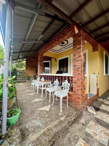 a group of white tables and chairs on a patio at GUEST HOUSE at Tayabas Quezon! in Dapdap