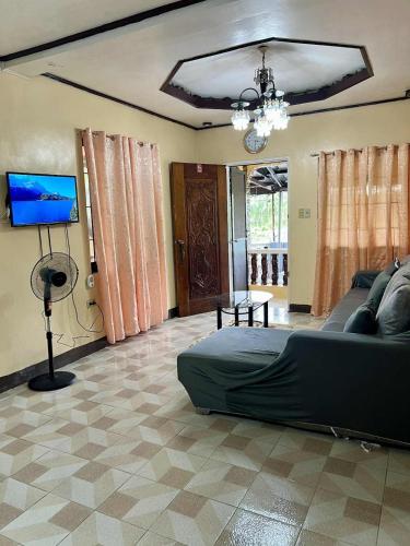 a living room with a couch and a flat screen tv at GUEST HOUSE at Tayabas Quezon! in Dapdap
