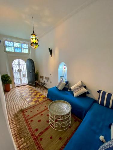 a living room with two beds and a table at Dar La Casbah Private Riad Stay with Moroccan Breakfast in Tangier