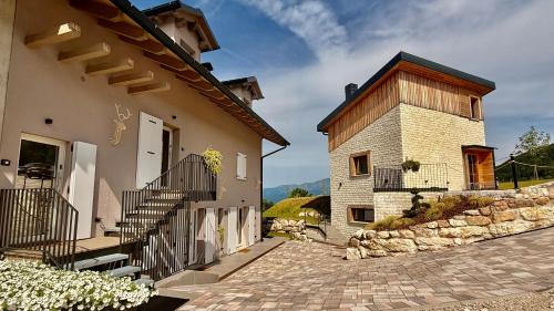 a house with a staircase next to a building at La Tana del Cervo del Maso K in Folgaria