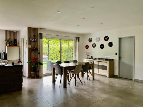 a kitchen and dining room with a table and chairs at Maison climatisée avec grand jardin, piscine privée et Jacuzzi in Saint-Didier