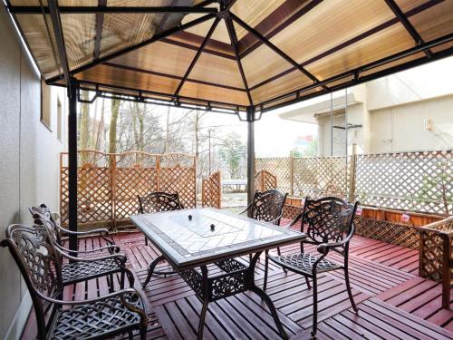 un patio con tavolo e sedie su un ponte di Kurobe Sun Valley Hotel - Vacation STAY 90890v a Ōmachi
