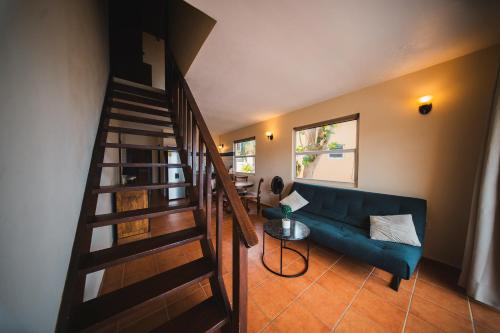 a living room with a blue couch and a staircase at Appartement 8 & 9- Lagun blou resort - Curaçao in Lagun