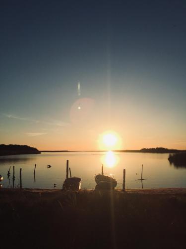 a sunset over a body of water with two boats at Le Pavoncelle in Valledoria