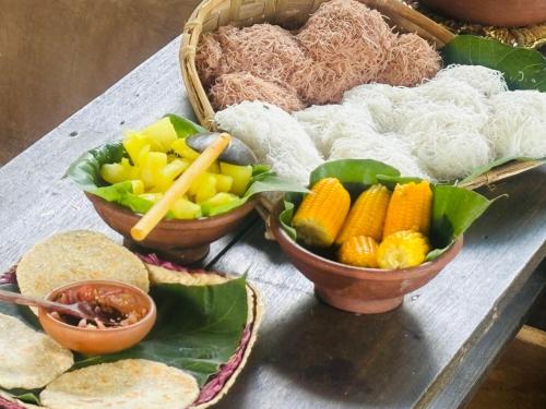 a table with several bowls of food on it at Mati Gedara Resort in Digana