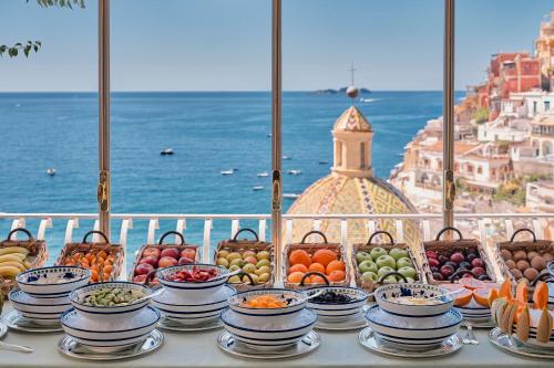 a table with bowls and plates of fruits and vegetables at Le Sirenuse in Positano
