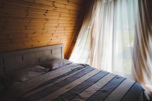 a bedroom with a bed and a window at Kazbegi Mountain View Cottage in Kazbegi