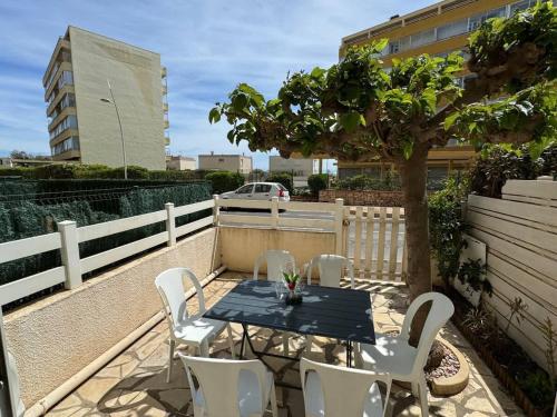 une table et des chaises sur une terrasse avec un arbre dans l'établissement Valras-Loc - Plaisir Balneaire, à Valras-Plage