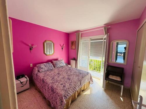 - une chambre rose avec un lit et une fenêtre dans l'établissement Valras-Loc - Appartement Trois Etoiles, à Valras-Plage