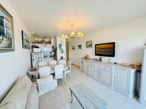 un salon avec un canapé et une table dans l'établissement Valras-Loc - Appartement Trois Etoiles, à Valras-Plage