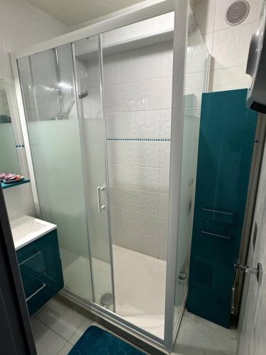une salle de bain avec une douche avec une porte vitrée dans l'établissement Valras-Loc - Evasion marine a deux pas de la plage, à Valras-Plage