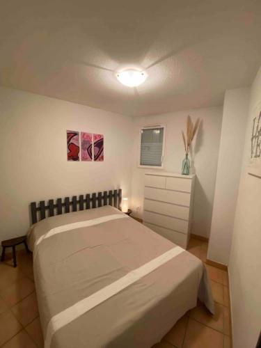 une chambre avec un lit et une commode dans l'établissement Valras-Loc - T2 Piscine Terrasse, à Valras-Plage