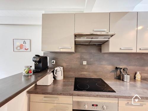 a kitchen with white cabinets and a stove top oven at La Loggia - Premium apartment 60 m2 in Châtellerault
