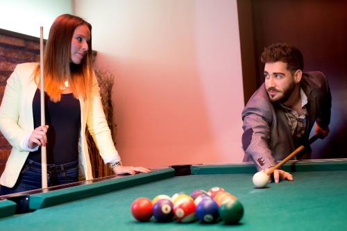a man and a woman playing a game of pool at Boutique Hotel Sopianae in Pécs