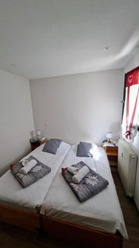 une chambre avec deux lits avec des oreillers dessus dans l'établissement La loge - EN PLEIN COEUR DU VILLAGE, à Saint-Gervais-les-Bains