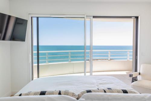 une chambre avec un lit et une vue sur l'océan dans l'établissement Valras-Loc Privatisez le 9e etage de lArchipel, à Valras-Plage