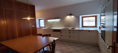 a kitchen with a wooden table and a tableasteryasteryasteryasteryasteryasteryastery at Große Wohnung mit Garagenparkplatz in Vols am Schlern