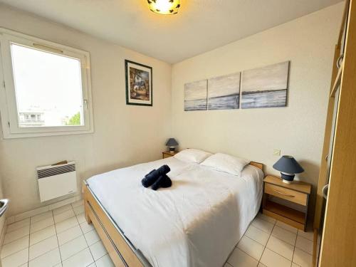 une chambre avec un lit avec un animal en peluche dessus dans l'établissement Valras-Loc - Appartement du stade, à Valras-Plage