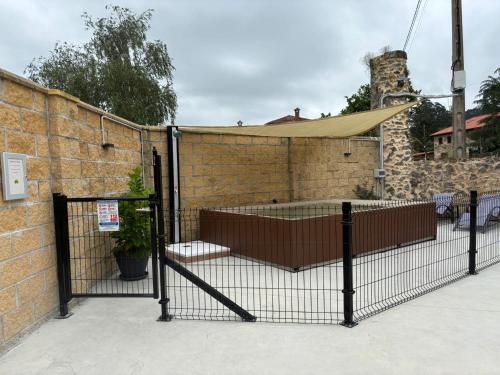 a fence in front of a brick wall at encanto rural en arce by urbanhosting in Arce