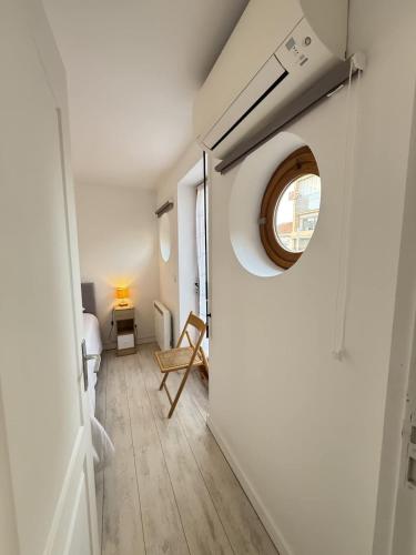 une pièce avec un couloir avec une fenêtre ronde dans l'établissement Valras-Loc Villa Cecile - Maison Centre & Plage, à Valras-Plage