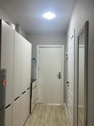 a hallway with white cabinets and a white door at ბამბუ ბიჩ ციხისძირი bamboo beach tsikhisdziri in Tsikhisdziri