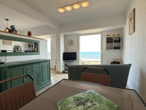 une salle à manger avec une table et une vue sur l'océan dans l'établissement Valras-Loc - Front de Mer avec Vue Superbe, à Valras-Plage