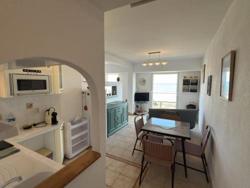 Il dispose d'une cuisine et d'un salon avec une table et une salle à manger. dans l'établissement Valras-Loc - Front de Mer avec Vue Superbe, à Valras-Plage