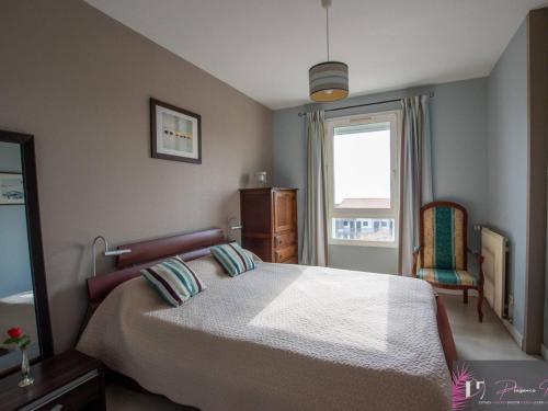 une chambre avec un grand lit et une fenêtre dans l'établissement Appartement 4-6 personnes avec balcon vue mer et parking - FR-1-825-10, à La Rochelle