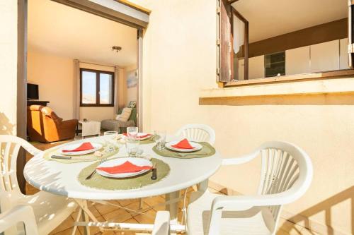 une salle à manger avec une table blanche et des chaises blanches dans l'établissement Valras-Loc T2 spacieux et calme au coeur de Valras, à Valras-Plage